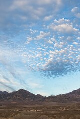 Illuminated altocumulus clouds at sunset over badlands in Death Valley National Park