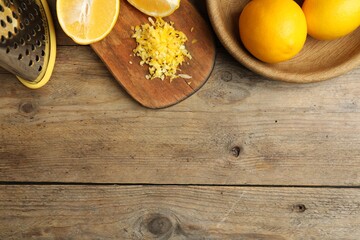 Obraz na płótnie Canvas Lemon zest and fresh fruits on wooden table, flat lay. Space for text