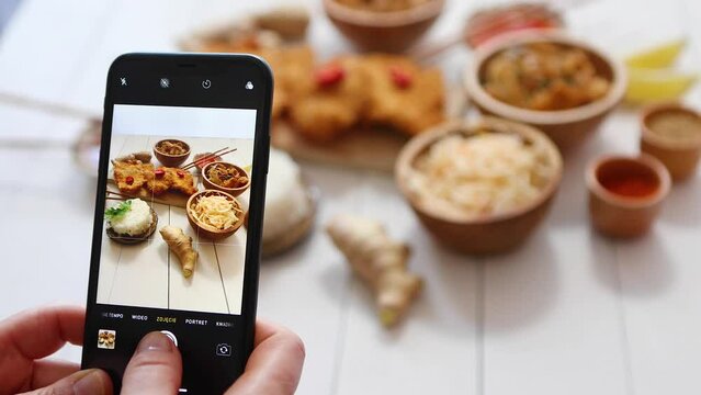 Woman taking photo of chinese style, deep fried, battered chicken