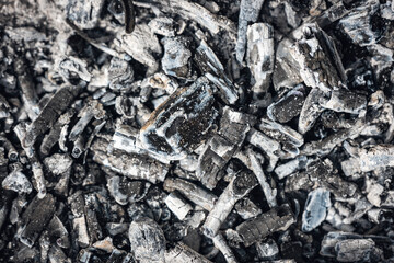 The remains of an extinct fire, charred wood and ashes, background texture