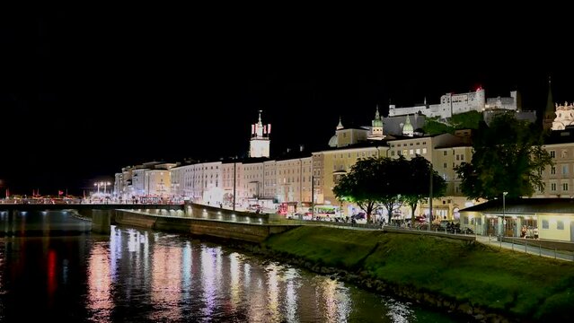 Salzburg, Austria, August 2022. Fascinating night shot of the old town. A lightning bolt lights up the sky blue in the third second of the footage. The fort at the top of the hill stands out