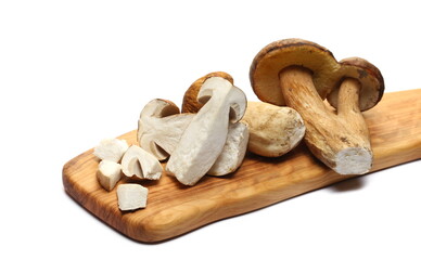 Boletus edulis slice and half on cutting board isolated on white  