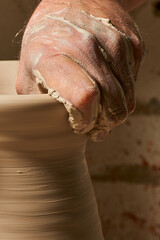 Craftsman molding a clay vase