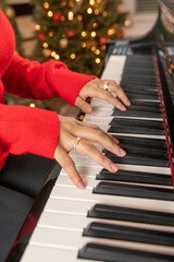 hands playing piano red christmas holiday