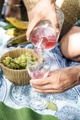 Woman holding a glass while being served wine. Relaxed atmosphere.