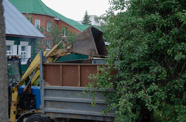 An excavator is loading earth into a dump truck, which is heavy construction equipment on construction site