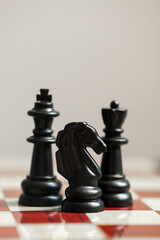 Black chess pieces on a chessboard. vertical photo