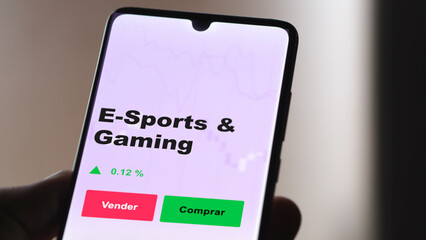 Un inversor está analizando el e-sports & gaming etf fondo en pantalla. Un teléfono muestra los precios del ETF para invertir. Texto en español.