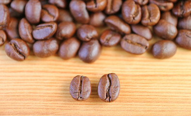 Closeup of Robusta VS Arabica Roasted Coffee Beans with Blurry Coffee Beans Pile in the Backdrop