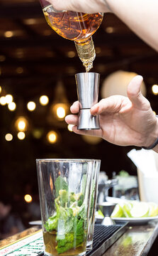 Bartender serving alcohol in a cocktail. Cocktail preparation in a night environment. It can be a hotel, a restaurant or a night club.