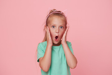 Portrait of surprised cute little toddler girl child over pink background. Looking at camera....