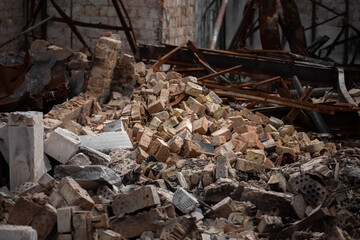 Stone dump on the ruins of a private house. A pile of construction debris and stones. Remains of bricks in a bucket.