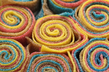 chewy leaf marmalade in stripes multi-colored yellow blue red green rolled into snails close-up. Sweets day healthy treats. Dessert with agar gelatin. low calorie desserts