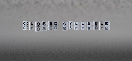 closed syllable word or concept represented by black and white letter cubes on a grey horizon background stretching to infinity