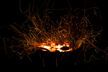Campfire flame sparks long exposure isolated on black background. Fire sparkles long exposure...