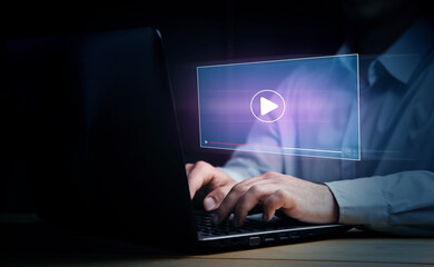 man working on laptop, watching video player