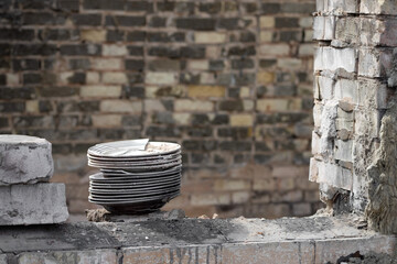 A stack of plates in the middle of a war-torn house. Findings of things in the ruins of the house....