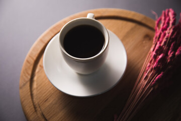 cup of coffee with flower on wooden board