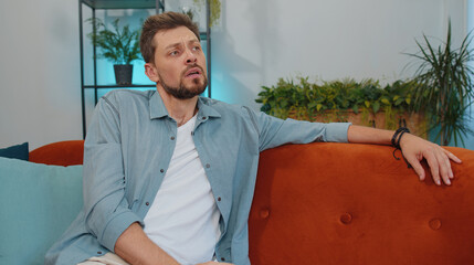 Portrait of sad lonely man lying at home looks pensive thinks over life concerns or unrequited...