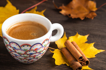 Coffee in a cup near autumn leaves.