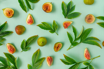 A seamless pattern or backdrop made of fresh green leaves and figs against pastel green background. Design for seasonal banner or advertisement