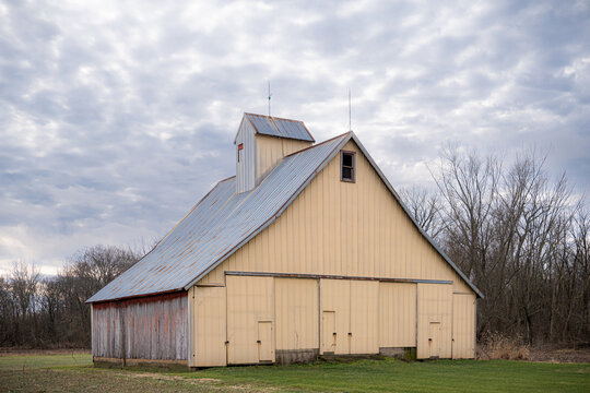 an old yellow barn with a dramatic cloudy sky
