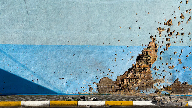 Traces from the burst of a mortar shell on the wall of the cultural center