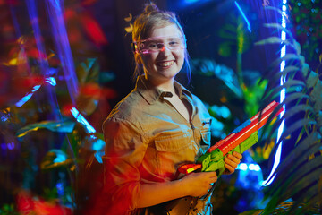 Obraz premium smiling modern child with toy gun in virtual reality