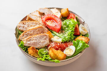 Chicken salad. Caesar salad with chicken breast fillet in a plate on white background. Healthy diet food