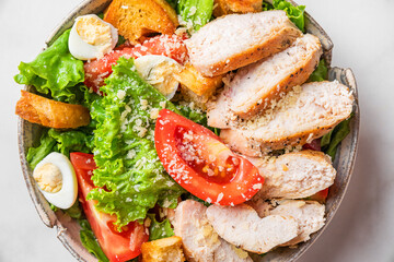 Chicken salad. Close u p of Caesar salad with chicken breast fillet in a plate on white background. Top view