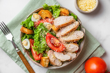 Caesar salad. Healthy salad made of chicken breast fillet, lettuce, tomatoes, quail eggs, croutons, parmesan cheese