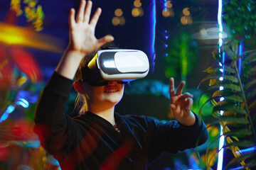 happy trendy girl in virtual reality in vr headset exploring