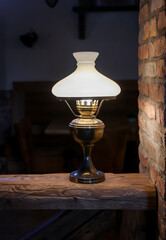Eine Stehlampe auf einem Sockel aus einem Holzpfosten.