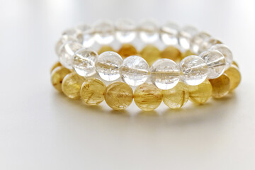 Golden rutilated quartz and clear quartz bracelets on the table. 