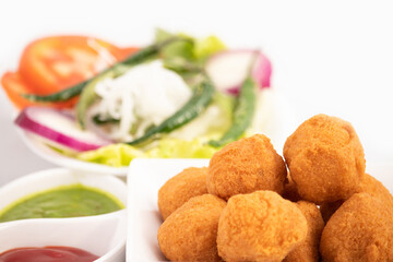 Indian Delhi Street Chaat Food Ram Laddu Pakode Or Raam Ladoo Pakore Is Made Of Moong Dal, Yellow Mung Lentils, Chana Daal. Served With White Radish Mooli, Nimbu, Tamatar, Imli Sauce, Green Chutney