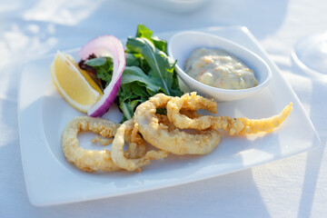 Eating or holding calamary on plate