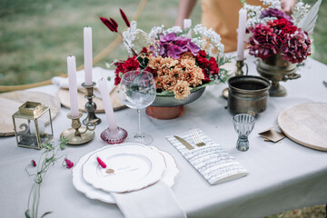 Modern wedding table decorated with plates, cutlery and flowers