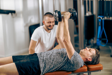 Man Doing Workout With Coach In A Gym