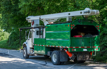 Arbor utility truck with bucket lift parked by forest. © Robert
