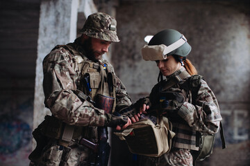 Fully equipped and armed ukrainian soldiers checking their equipment while taking a break..