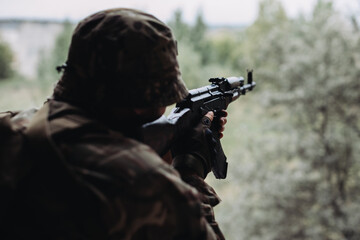 Soldier in war, with weapons in his hands, aim at the enemy