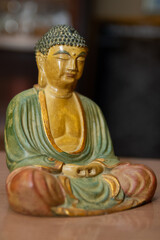 A colorful Buddha statue on a table.