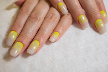 Manicured hands of a beautiful woman. Delicate nails with colorful manicure in beauty salon