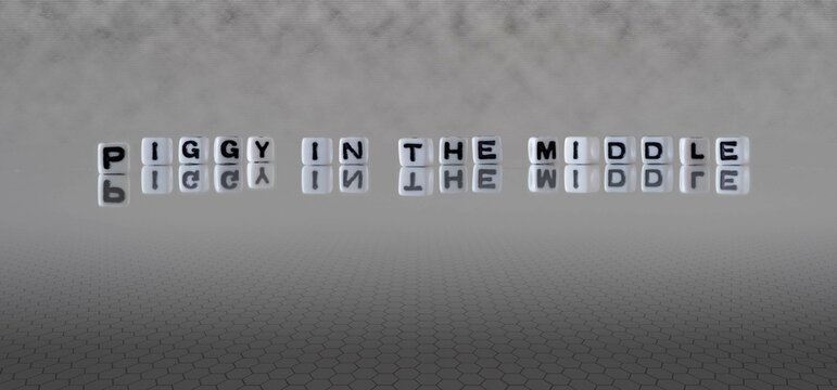 piggy in the middle word or concept represented by black and white letter cubes on a grey horizon background stretching to infinity