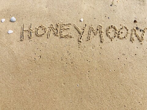 on the beach is carved with letters in the smooth sand the writing Honeymoon