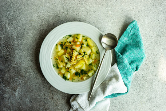 Overhead view of a bowl of healthy vegetable and pasta soup