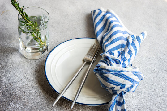 Place setting with stripped napkin and a glass of rosemary water
