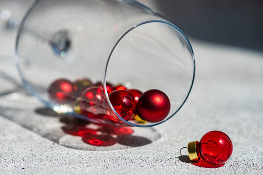 Close-Up of miniature Christmas bauble decorations spilling out of a glass like a fallen glass of red wine