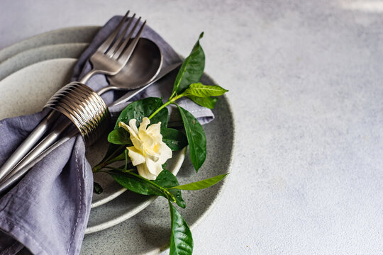 Close-Up of a rustic place setting on a table with a white gardenia flower