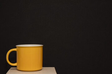 Yellow mug on black background simple concept